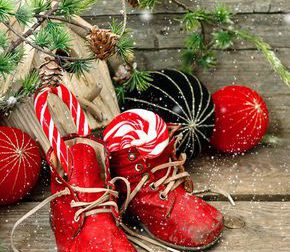 christmas stocking. nostalgic decoration with antique toys and vintage baby shoes over wooden background. retro style picture with falling snowflakes effect